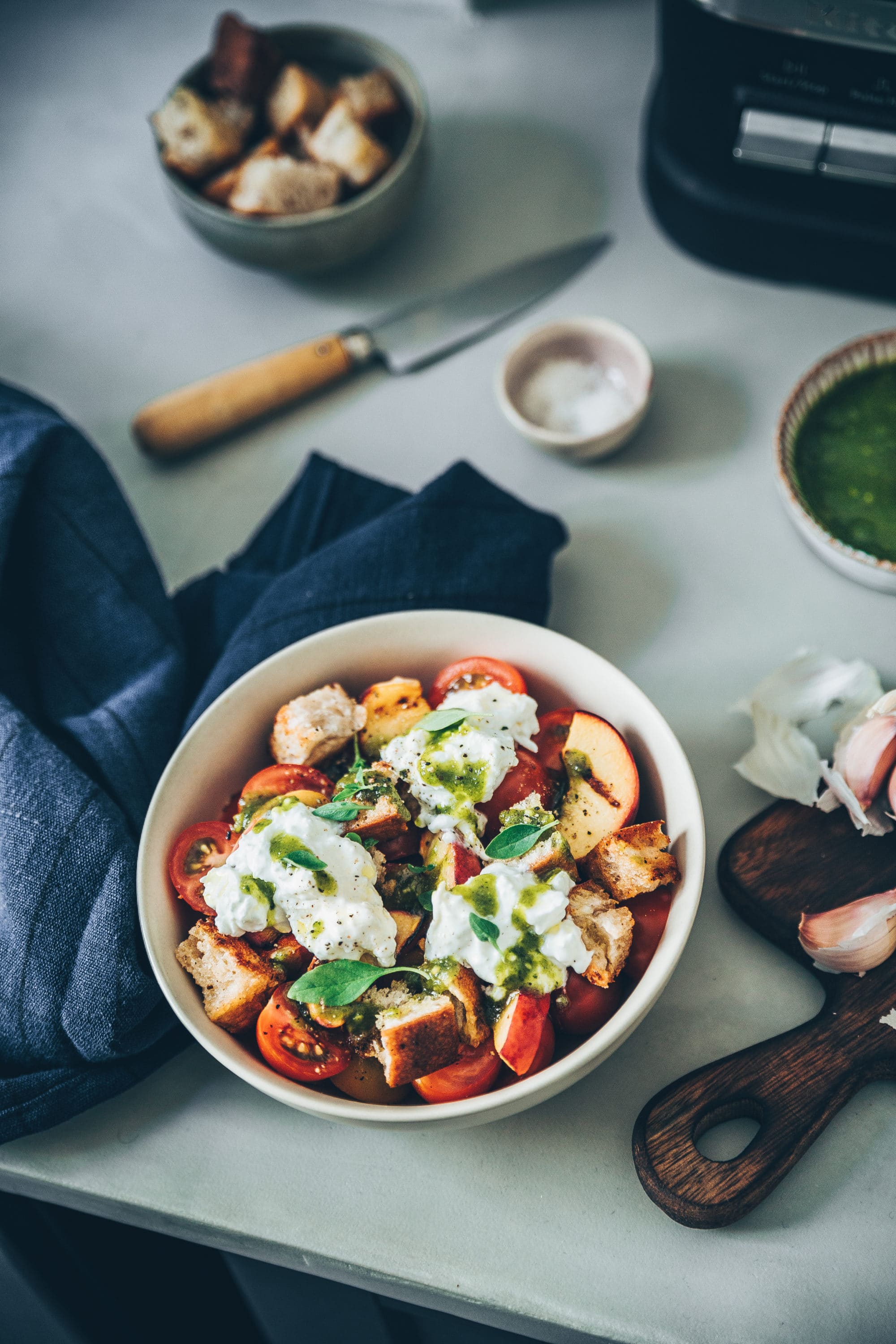 La panzanella vous connaissez ? Cette recette typique de la cuisine pauvre Toscane qui est une simple salade de pain très ancienne datant de plusieurs siècles. À l’origine il n’y avait pas de tomates mais uniquement des herbes, de l’oignon rouge, de l’huile d’olive, du vinaigre et du concombre. Puis peu à peu, la tomate est venu colorer cette belle salade. De mon côté j'ai décidé de la revisitée. Je ne vous cache plus ma passion pour les salades sucrées salées auxquelles on ajoute quelques fruits. Du coup pour cette fois ce sera une panzanella aux pêches rôties et pesto de pistaches !