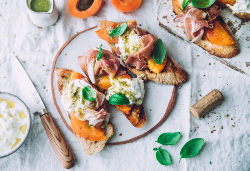 Crostini abricots rôtis, stracciatella, prosciutto & pesto de pistaches